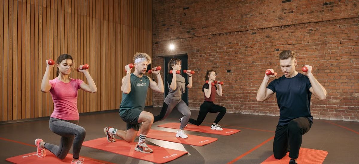 Indoor group workout session with dumbbells focusing on strength and fitness.