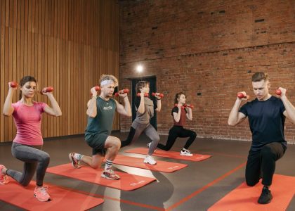 Indoor group workout session with dumbbells focusing on strength and fitness.
